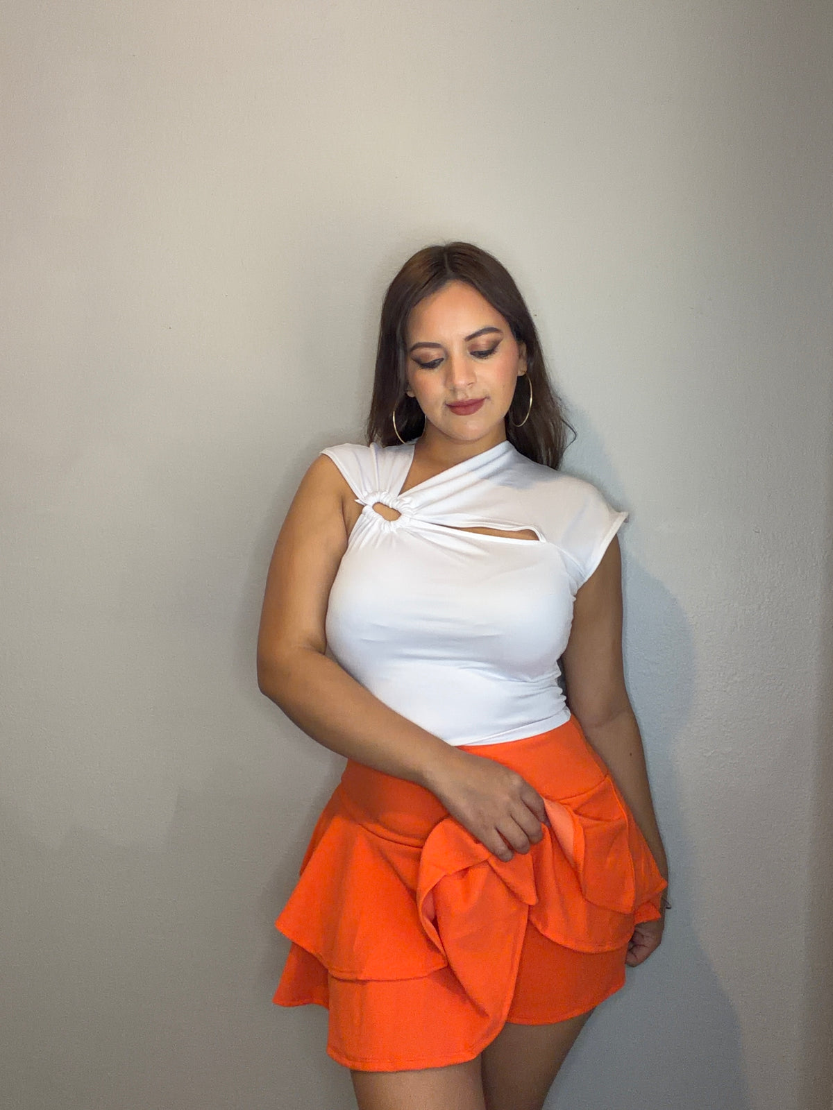 orange skirt with built-in shorts and asymmetric blouse with a front cutout.